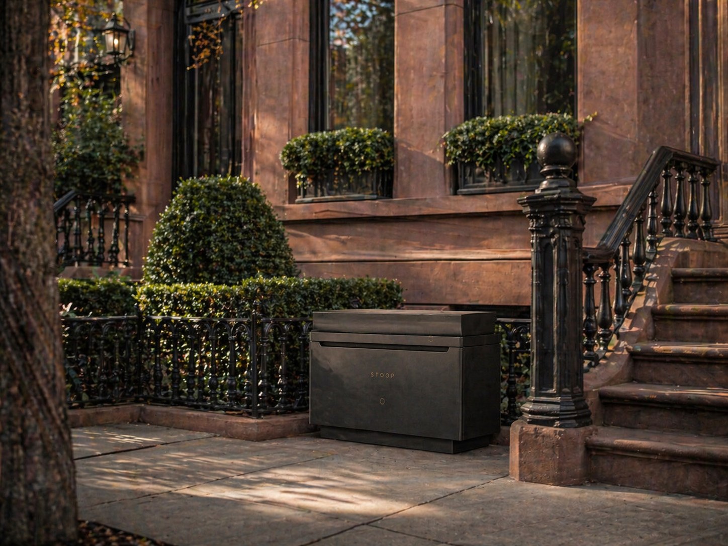 Stoop placed in the garden apron beside a brownstone stoop, nested between iron fencing and clipped boxwood.
